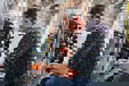 man performing maintenance or repair work on an HVAC