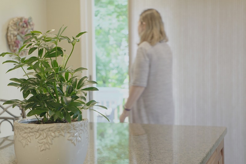 Woman standing next to an open door in her house