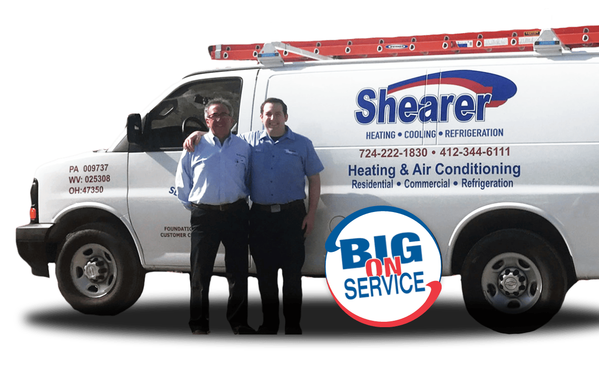 Shearer Heating, A/C & Refrigeration employees standing in front of one of their HVAC service vehicles.